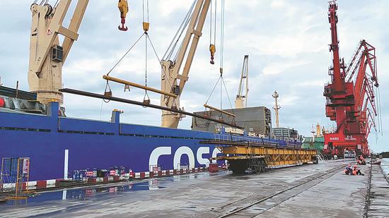 Steel rails are unloaded from a vehicle onto a ship at Fangchenggang Port, Guangxi Zhuang autonomous region. (Photo/China Daily)