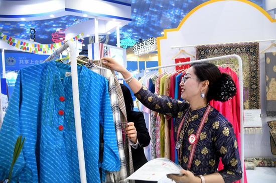 An exhibitor introduces products to a guest during the 2021 Shanghai Cooperation Organization (SCO) International Investment and Trade Expo in Qingdao, east China's Shandong Province, April 26, 2021.(Xinhua/Li Ziheng)