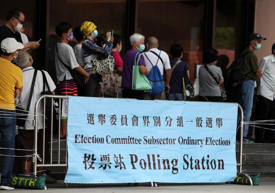 Citizens queue to enter a polling station at the Sha Tin Town Hall in south China's Hong Kong, Sept. 19, 2021. (Xinhua/Li Gang)