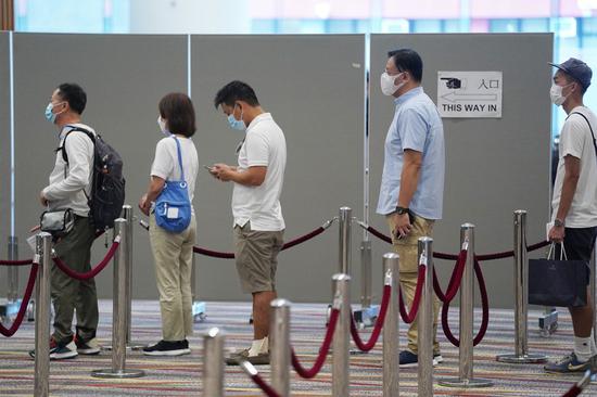 People queue to cast their ballots at a polling station at Hong Kong Convention and Exhibition Center in Hong Kong, south China, Sept. 19, 2021. (Xinhua/Wang Shen)