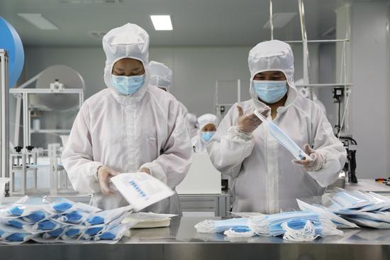 Workers pack face masks at a workshop in Majiazhuang Village of Nanlong Township in Linxia City, northwest China's Gansu Province, March 26, 2021. (Xinhua/Ma Sha)