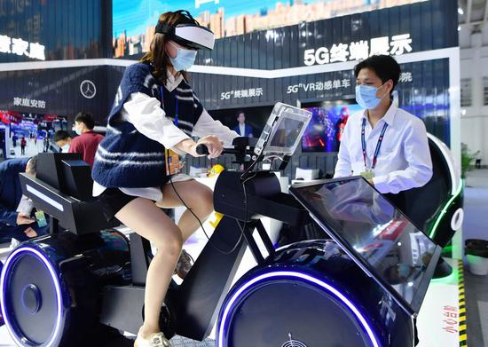 A visitor tries a VR spinning based on 5G technology at the digital achievements exhibition during the fourth Digital China Summit in Fuzhou, southeast China's Fujian Province, April 25, 2021. (Xinhua/Wei Peiquan)