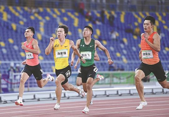 Eventual winner Tang Xingqiang (yellow) accelerates away from Xie Zhenye (right) during Wednesday's 200m final. (Photo/XINHUA)