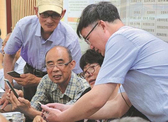 Retirees in Yancheng, Jiangsu province, learn to use smartphones in June. (Photo/China Daily)