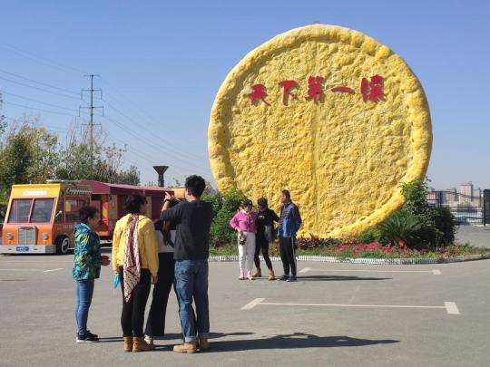 Tourists take photos at the Urumqi Naan Cultural Industrial Park.(Photo/chinadaily.com.cn)