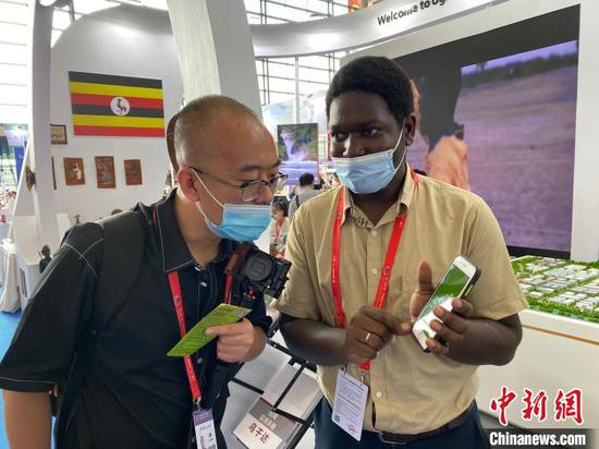 Ugandan business man Ssonko Wilson (R) introduces products at the second China-Africa Economic and Trade Expo in Changsha, capital of Hunan Province, Sept. 29, 2021. (Photo/China News Service)