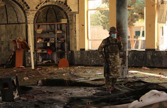 An Afghan Taliban member inspects the site of an explosion at a mosque in Kunduz city, northern Afghanistan, Oct. 8, 2021. (Photo by Ajmal Kakar/Xinhua)