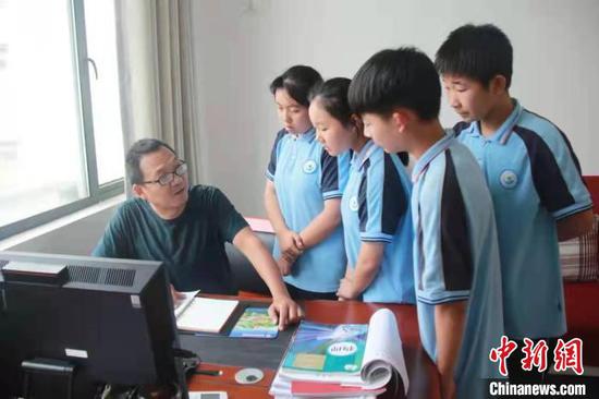 Zhu Xijun is teaching students in his office at Gufu Township Junior High School (Photo: China News Service/Nie Zhiyuan)