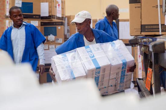 Workers were unloading the Sinopharm COVID-19 vaccines donated by China in Bujumbura, the commercial capital of Burundi, on Oct. 14, 2021. (Photo: Xinhua/Evrard Ngendakumana/)