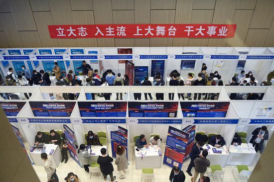 Graduating students search for job opportunities at a job matching fair at Tsinghua University in Beijin, on March 16, 2021. (Photo/Xinhua)