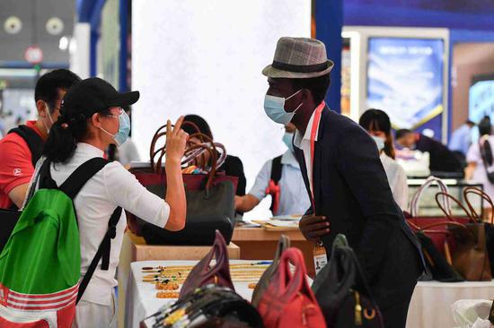 A visitor (left) inquires about African products at the second China-Africa Economic and Trade Expo in Changsha, Hunan province, on Sept 28. More than 300 African enterprises displayed their products offline during the offline-and-online expo.(Photo/Xinhua)