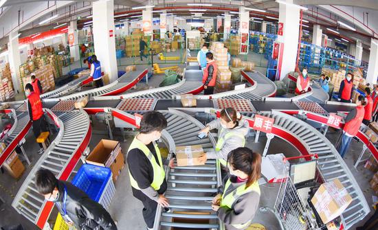 Workers sort out packages at a sorting center in Lianyungang, East China's Jiangsu province, Nov 11, 2020, on the occasion of an annual online shopping spree. (Photo/Xinhua)