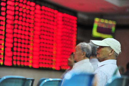 Investors check share prices at a securities firm in Nanjing, Jiangsu province. (Photo: China Daily/China Daily)