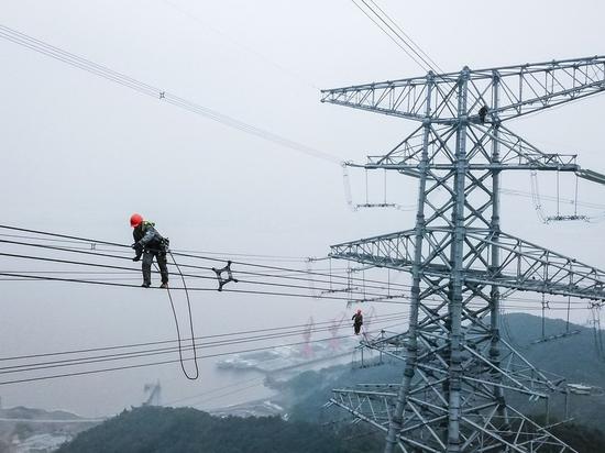 Aerial photo shows technicians of State Grid Zhejiang Electric Power Company checking power transmission lines to make sure the stable operation of local power supply in Zhoushan, east China's Zhejiang Province, Oct 23, 2020. (Photo/Xinhua)