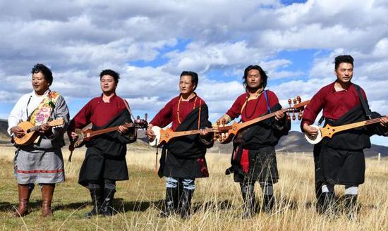 Artists play Tibetan instruments on prairie in Sichuan