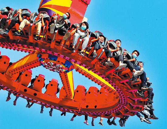 Visitors ride the sky wheel at Shijingshan Amusement Park in Beijing. (Photo: China Daily/Jiang Dong)