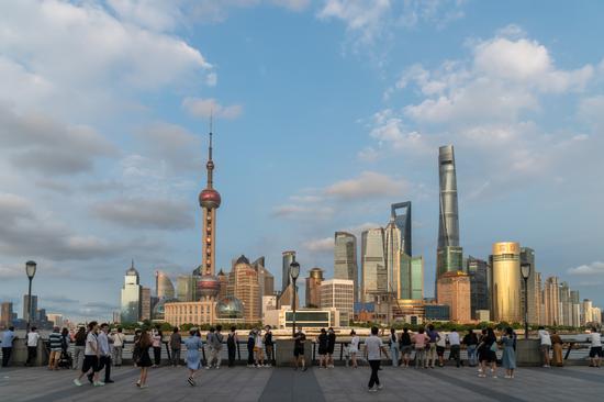 Tourists admire views at the Bund in Shanghai in September. (Photo: China Daily/Wang Gang)