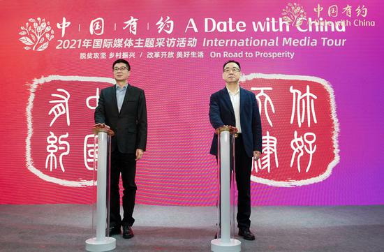 Niu Yibing (left), deputy minister of the Cyberspace Administration of China, and Zhou Derui, member of the CPC Tianjin Standing Committee, press buttons to start the third leg of the 'A Date with China' tour during the launch ceremony in Tianjin Friday. (Photo/chinadaily.com.cn)