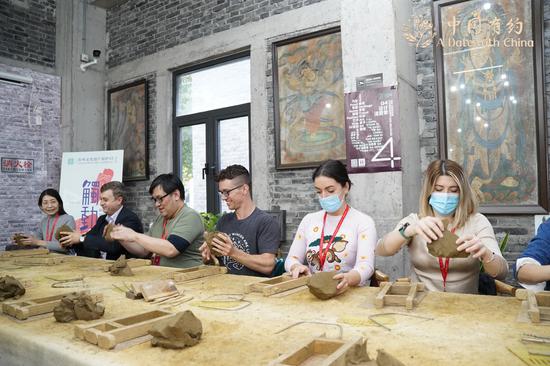 China-based foreign media correspondents and foreign internet influencers experience kiln brick making at the Suzhou Museum of Imperial Kiln Brick in East China's Jiangsu province on Oct 25, 2021. (Photo/chinadaily.com.cn)