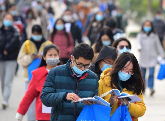 A photo of applicants studying for the 2021 national civil servant exam in front of the Wuxi Higher Vocational School of Tourism & Commerce in Jiangsu province on Nov 29, 2020. （Photo/Xinhua）