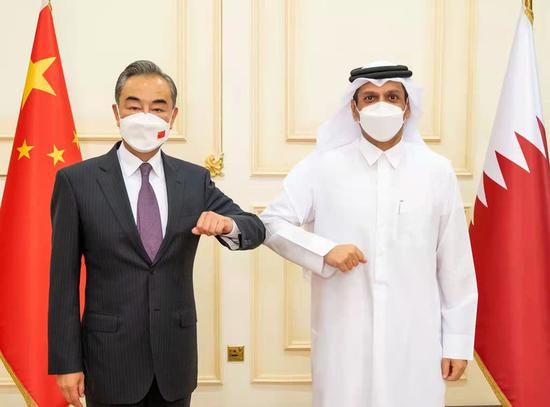 Chinese State Councilor and Foreign Minister Wang Yi (L) meets with Qatari Deputy Prime Minister and Foreign Minister Sheikh Mohammed bin Abdulrahman Al Thani in the Qatari capital of Doha, on Oct. 26, 2021. (Photo by Yang Yuanyong/Xinhua)