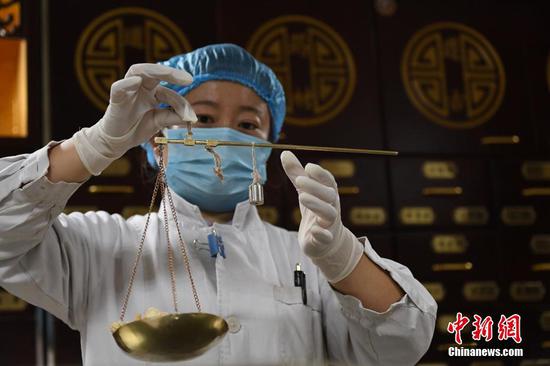 A medical worker weighs traditional Chinese medicine, Oct. 26, 2021, Lanzhou, Gansu Province. (Photo/China News Service)
