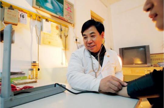 Ma Wenfang measures the blood pressure of a patient on Jan 6, 2013. (Photo/China News Service)