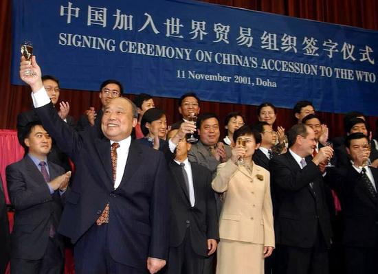File photo shows Shi Guangsheng (L, front), then Chinese Minister of Foreign Trade and Economic Cooperation, celebrating with others after signing the protocol of China's accession to the World Trade Organization (WTO) on behalf of the Chinese government in Doha, Qatar, Nov. 11, 2001. China became a formal WTO member on Dec. 11, 2001. (Xinhua/Wang Jianhua)