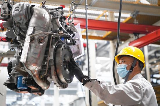 A worker operates at a workshop of the Dongan Auto Engine Co., Ltd. in Harbin City of northeast China's Heilongjiang Province, April 9, 2021. (Xinhua/Wang Jianwei)