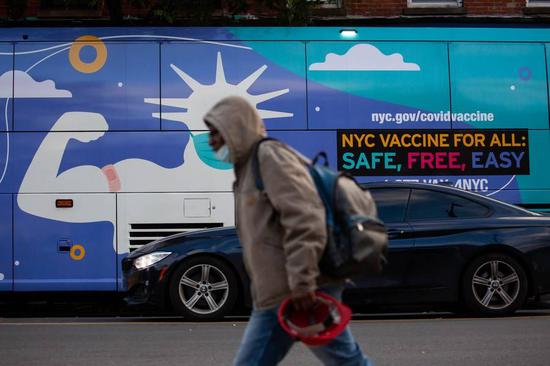 A pedestrian walks in front of a COVID-19 vaccination site in the Brooklyn borough of New York, the United States, Nov. 19, 2021. (Xinhua/Michael Nagle)