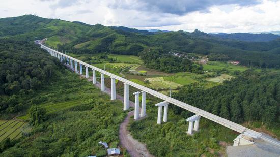Aerial photo taken on July 29, 2020 shows the China-Laos railway over the villages and fields in northern Laos. (Photo by Pan Longzhu/Xinhua)