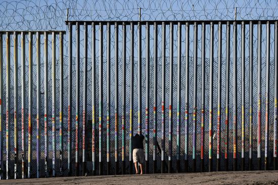Photo taken on Jan. 10, 2019 shows a man in front of the U.S.-Mexico border barrier in Tijuana, Mexico. (Xinhua/Xin Yuewei)