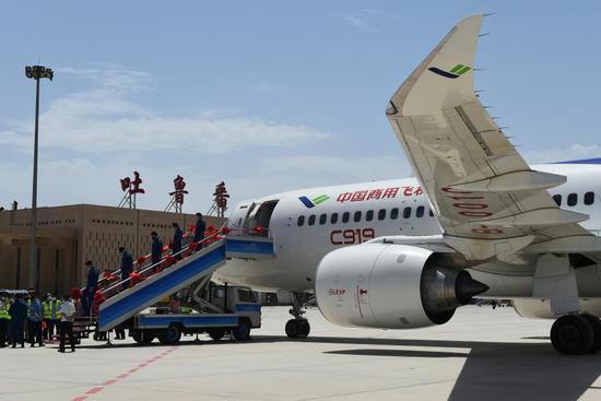 Staff members of a C919 large passenger aircraft disembark from the plane at the Turpan Jiaohe Airport in Turpan, northwest China's Xinjiang Uygur Autonomous Region, June 28, 2020. (Photo by Liu Jian/Xinhua)