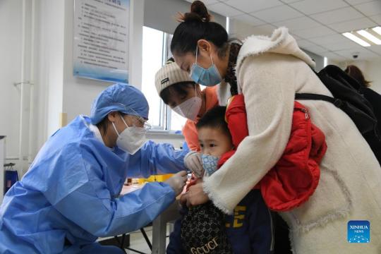 A medical worker inoculates a child with the second dose of COVID-19 vaccine at a vaccination site in Haidian district of Beijing, capital of China, Dec 5, 2021. (Photo/Xinhua)
