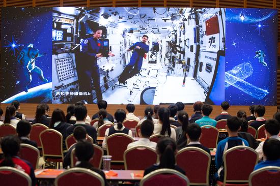 Shenzhou XIII crew members Wang Yaping (left) and Ye Guangfu give a lecture to students on Thursday from China's space station. During the class, fellow astronaut Zhai Zhigang introduced the special uniform Ye was wearing, saying it is called a 