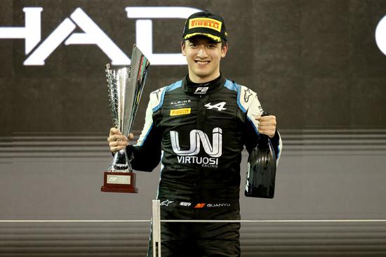 Zhou Guanyu celebrates on the podium after winning Sprint Race 2 of Round 8 of the 2021 Formula 2 championship at the Yas Marina Circuit in Abu Dhabi, United Arab Emirates, on Dec. 11, 2021. (QIAN JUN M via Xinhua)