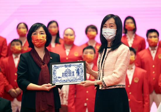 Ao Ieong U (R), Secretary for Social Affairs and Culture of the Macao SAR government, presents a gift to Yang Ning who heads a delegation of manland Olympians arriving in Macao on December 19, 2021 for a three-day visit. (Xinhua/Jia Haocheng)