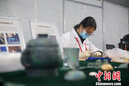 A archaeologist cleans up cultural relics at the Liulihe Site. (Photo Provided to China News Service by the Chinese Academy of Cultural Heritage)