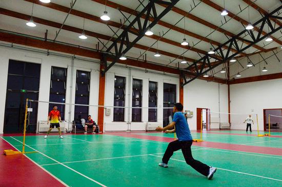 Employees play badminton after work at a polysilicon company in northwest China's Xinjiang Uygur Autonomous Region, Dec. 15, 2021. (Xinhua/Gao Han)