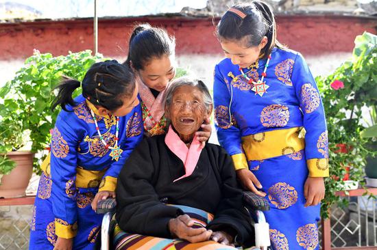 Sonam Drolma, 109, talks with her great granddaughters in the courtyard at home in Reguo Village of Gyaca County in Shannan, southwest China's Tibet Autonomous Region, March 24, 2020. The average life expectancy in Tibet in 2021 rose to 72.19 years, an increase of 1.09 years over 2020. (Xinhua/Zhan Yan)