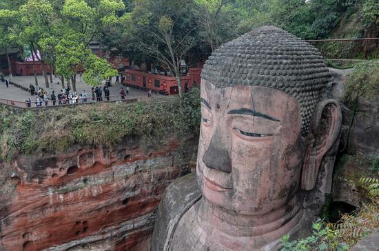 Tourists view the statue of the Leshan Giant Buddha in Leshan City, southwest China's Sichuan Province, March 23, 2020. (Xinhua/Zhang Chaoqun)