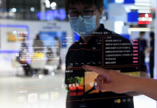 A staff member displays a smart mirror at the China International Digital Economy Expo 2021 in Shijiazhuang, north China's Hebei Province, Sept. 7, 2021.  (Xinhua/Wang Xiao)