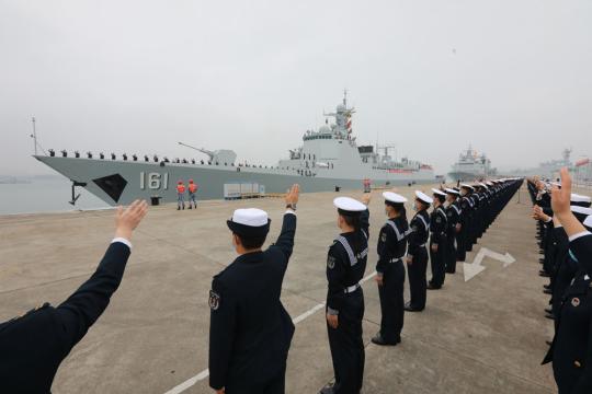 Military personnel wave goodbye to a fleet of the Chinese People's Liberation Army Navy at a military port in Zhanjiang, Guangdong province, on Saturday. The fleet will conduct an escort mission in the Gulf of Aden and the waters off Somalia. (Photo/Xinhua)
