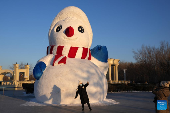 Tourists take photos at Sun Island International Snow Sculpture Art Exposition in Harbin