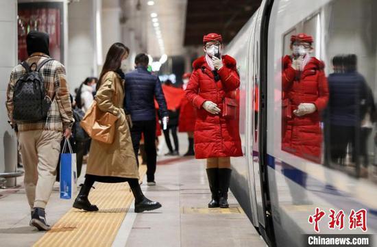 Photo shows a passenger boards a train at the Beijing Weat Station. (Photo/China News Service)