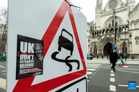 A sticker with a photo of WikiLeaks founder Julian Assange is seen on a road sign outside the Royal Courts of Justice in London, Britain, on Jan. 24, 2022. Assange has won permission from a court here to appeal against his extradition from the United Kingdom (UK) to the United States, where he faces espionage charges. (Photo by Stephen Chung/Xinhua)
