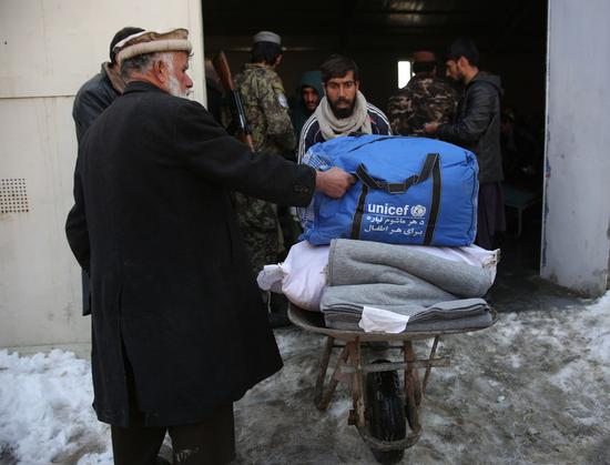 People receive donated relief assistance in Kabul, capital of Afghanistan, Jan. 18, 2022. (Photo by Saifurahman Safi/Xinhua)