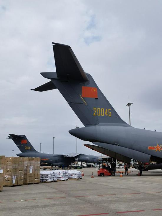 Photo taken with a mobile phone shows disaster relief materials loaded onto two Chinese air force transport aircraft to head for Tonga at the Guangzhou Baiyun International Airport in Guangzhou, south China's Guangdong Province, Jan. 26, 2022. (Xinhua/Ding Zengyi)