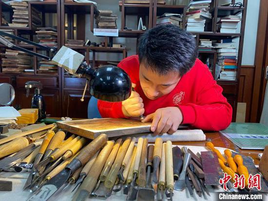 Li Zhenhao makes new year paintings via engraved block printing. (Photo/China News Service)