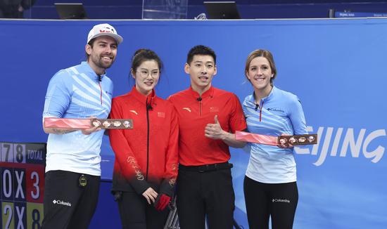 Fan Suyuan (2nd L) /Ling Zhi (2nd R) of China pose for photos with Christopher Plys (L) /Vicky Persinger of the United States after the curling mixed doubles round robin event of the Beijing 2022 Winter Olympics between China and the United States at National Aquatics Centre in Beijing, capital of China, Feb. 5, 2022. (Xinhua/Wang Jingqiang)